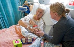 B8BTE8 Daughter visiting elderly mother patient in hospital bed Cheltenham UK. Image shot 02/2009. Exact date unknown.